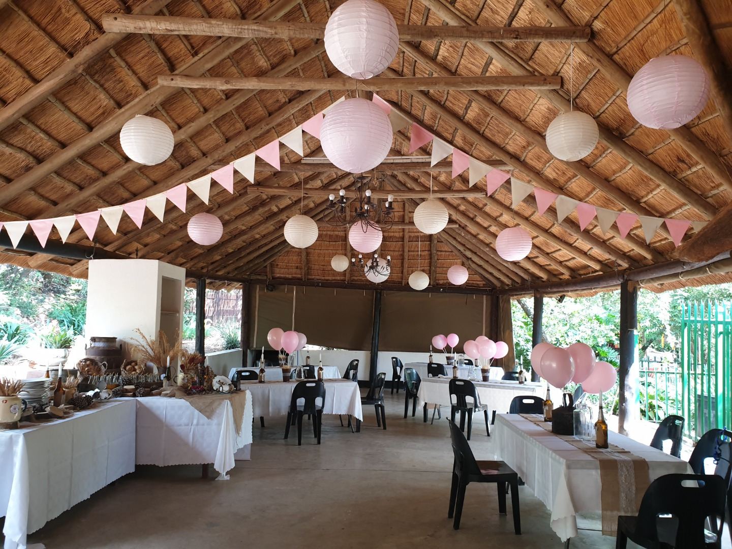 Soft pink and white lanterns above long buffet tables