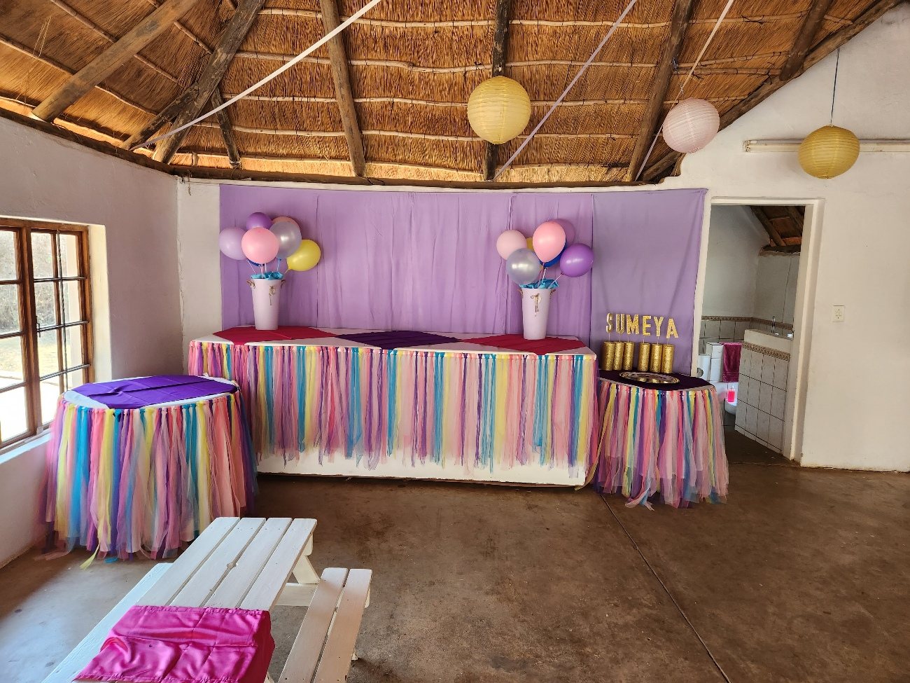 Purple and rainbow striped table with balloons