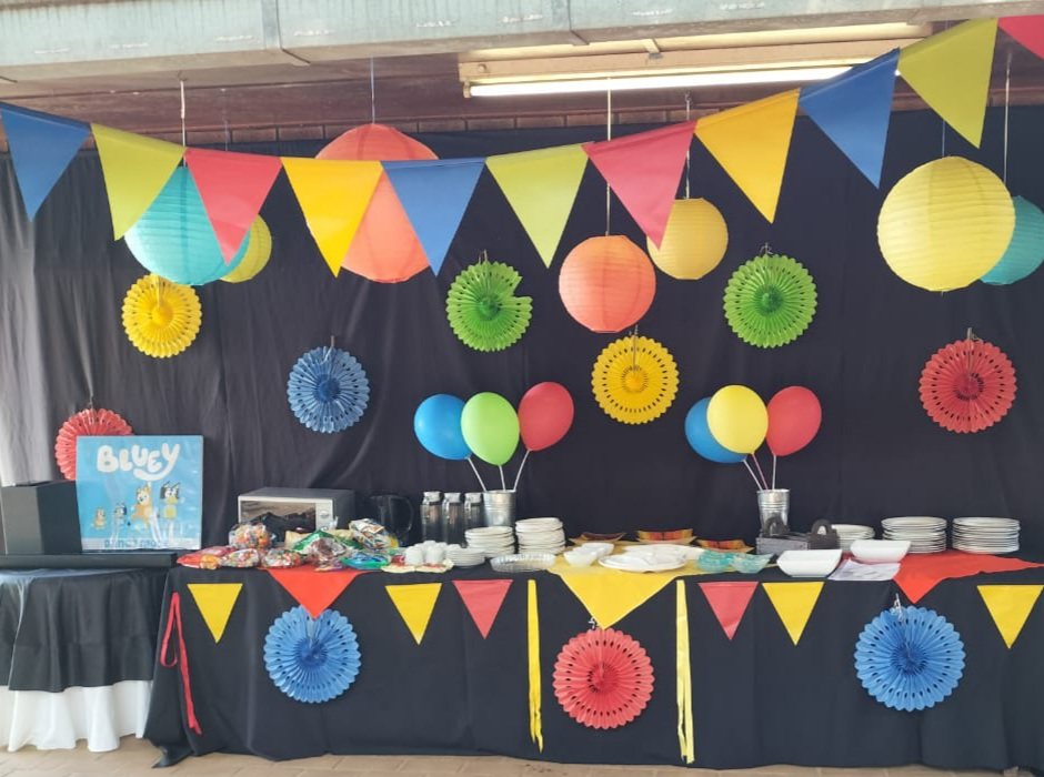 Paper fans and bunting above a dressed dessert table