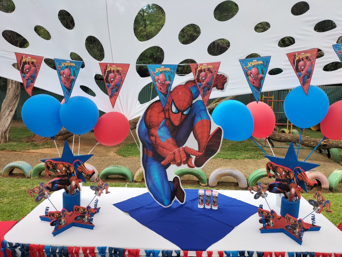 Superhero-themed table setting with cut-out characters