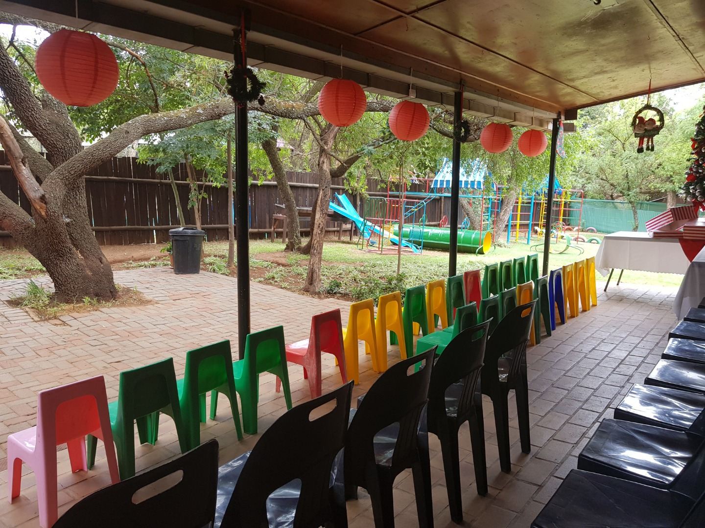 Bright chairs and lanterns set up under the trees for a ceremony