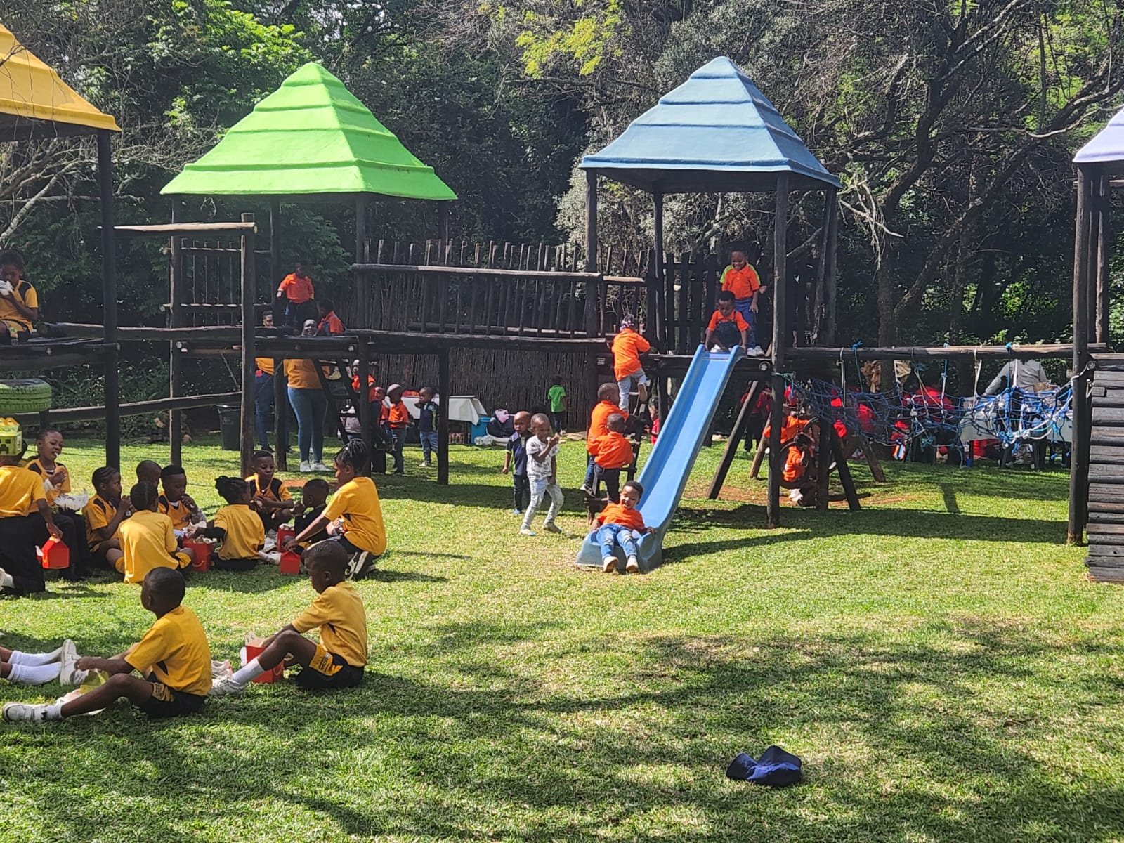 School group on the grass beside the jungle gyms