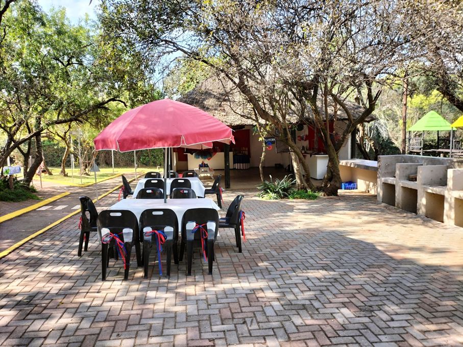 Umbrella-shaded tables on the paved patio at the Mini-Town Lapa