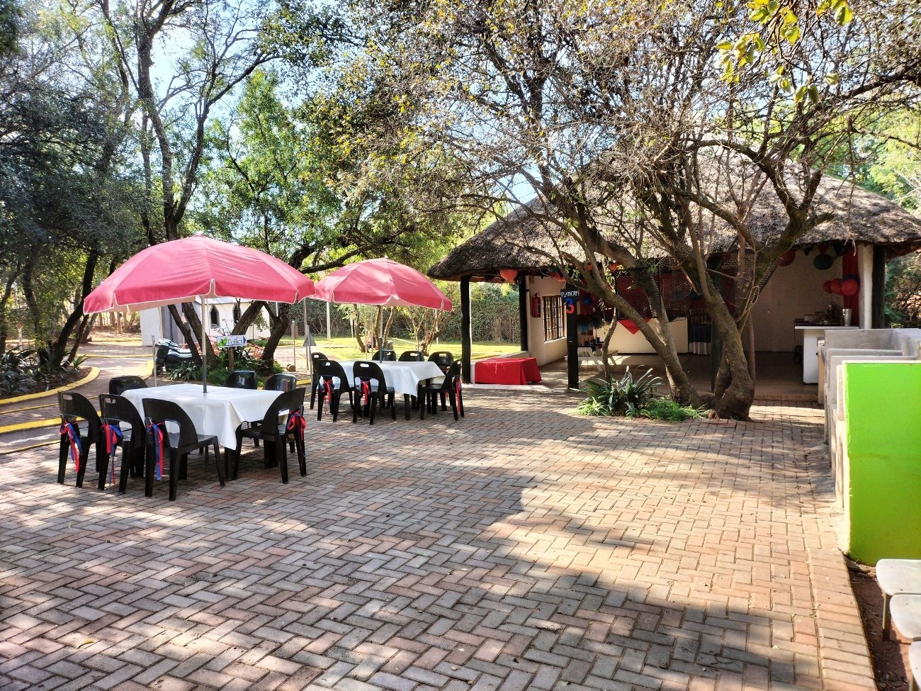 Pink umbrellas and set tables on the paving outside the lapa