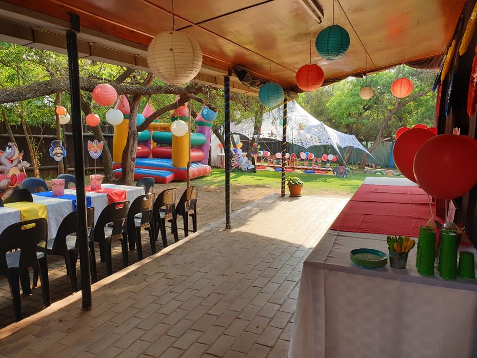 Long tables under the stoep with colourful lanterns overhead